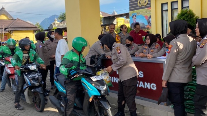 Personel Polres Singkawang membagikan beras kepada driver ojek online