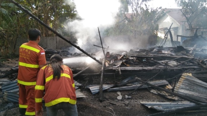 Petugas BKPS melakukan pemadaman di rumah warga yang terbakar, Jumat (5/9/2025).