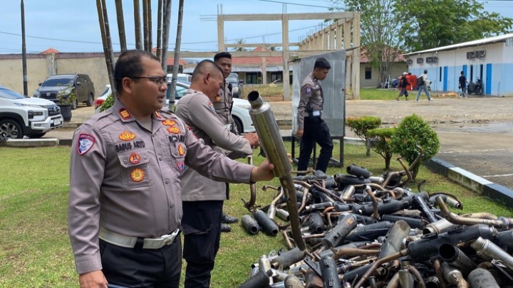 Kasat Lantas Polres Singkawang tunjukkan ratusan knalpot hasil penertiban balap liar. Foto (ist)